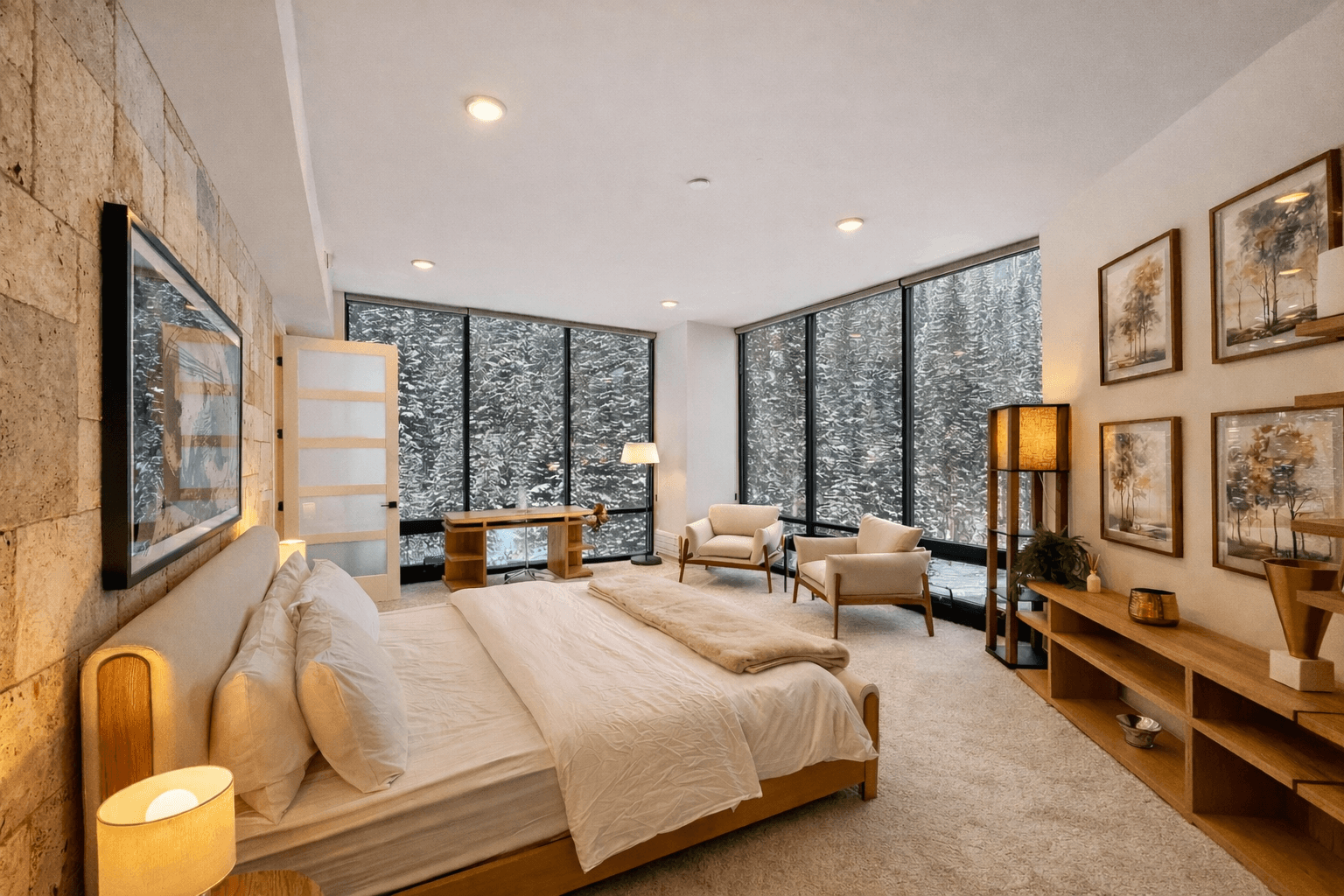 A bright penthouse bedroom with a wood-framed bed and tall windows onto snowy pines